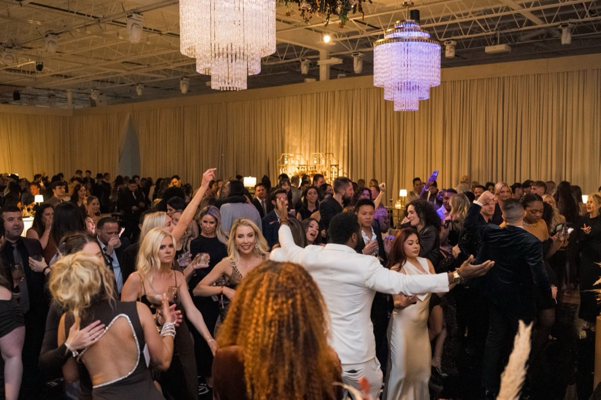Guests dancing under crystal chandeliers at an Astoria Event Venue gala