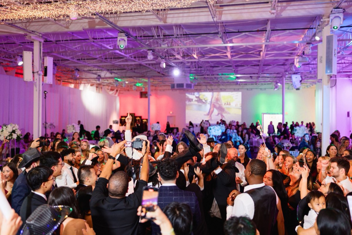 Wedding guests with hands in the air on the dance floor at Astoria Event Venue